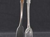 pair of silverware spoons with handles on a black background