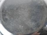 a close up of a silver plate with a person holding it