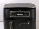 a black air fryer sitting on a white table