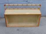 a wooden bench with a rattan seat on the sidewalk