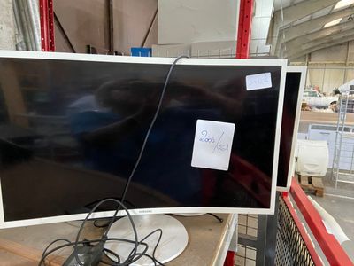 a computer monitor sitting on top of a table in a warehouse