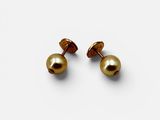 une paire de boucles d'oreilles en or et perles sur fond blanc
