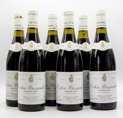 six bouteilles de vin sont alignées sur une surface blanche
