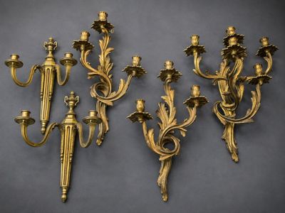 four antique brass wall sconces on a gray background