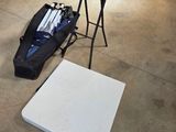 une table blanche et un sac noir posé par terre