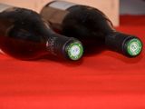 two bottles of wine sitting on a red table