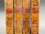 three old books are stacked on top of each other on a table