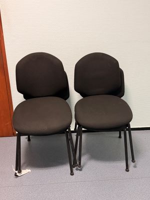 deux chaises de bureau noires placées devant un mur blanc