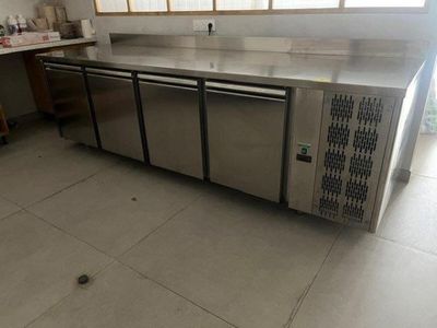 a large stainless steel counter in the middle of a kitchen