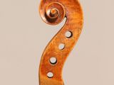 a close up of the back of a violin with a fiddle in the foreground