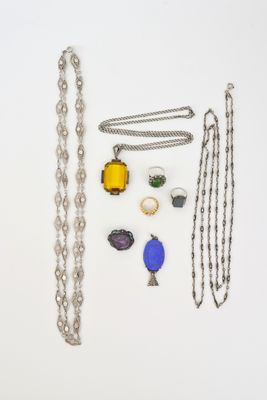 plusieurs colliers et bracelets différents disposés sur une surface blanche