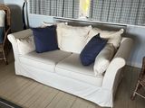a white couch with blue pillows in a living room