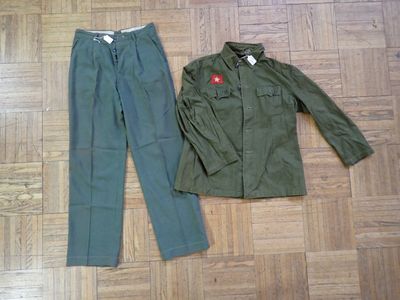 a green jacket and pants on the floor next to each other