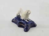 a figurine of a dog sitting on a pillow
