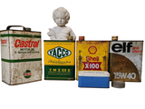 a statue of a child sitting next to some old oil cans
