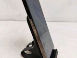 a close up of a cell phone on a stand on a white surface