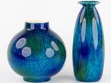 deux vases bleus posés l'un à côté de l'autre sur une surface blanche