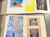 trois livres ouverts posés sur une table, avec des images dessus