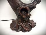 a statue of a woman holding a mirror on a table