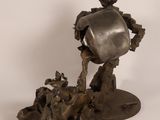 statue of a man with a bucket on his head on a rock