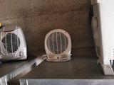 a small fan heater sitting on a shelf next to a toaster and a toaster