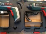 two bosch cordless drillets in a case on a table