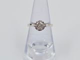 une bague en diamant posée sur un vase transparent