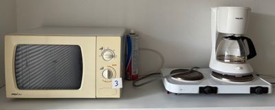 a microwave and a coffee maker sitting on a shelf