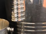 a silver bowl and a silver cup on a table