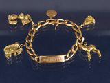 une image représentant un bracelet en or orné d'éléphants et d'une pièce de monnaie