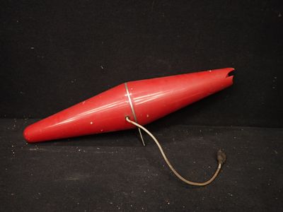 un objet rouge posé sur une surface noire