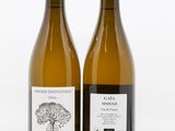 two bottles of wine sitting next to each other on a white surface