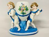 figurine en porcelaine représentant deux chérubins tenant un vase bleu et blanc