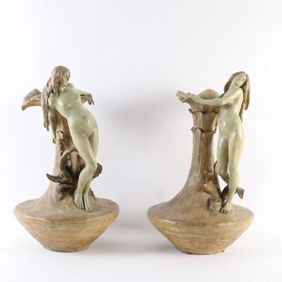 une paire de statues représentant une femme et un homme posées sur une souche d'arbre