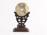 marble sculpture of a donut on a stand on a white background