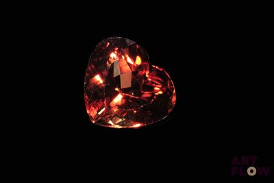 a heart shaped orange topazte gems on a black background