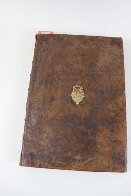 un livre marron orné d'un emblème doré