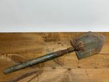 une vieille pelle rouillée posée sur une table en bois