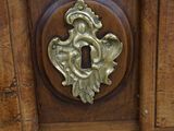 a close up of a wooden dresser with a brass knob