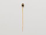 an image of a small gold object on a white surface
