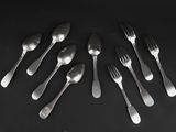 six forks and six spoons arranged in a circle on a black surface