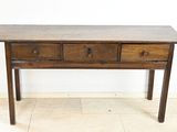 an old wooden table with three drawers on top of it