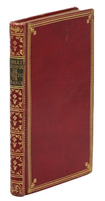 un vieux livre à la couverture rouge et à la bordure dorée
