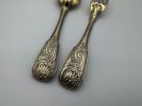 two silver spoons and a fork on a table
