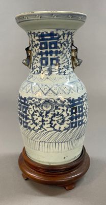 un grand vase bleu et blanc posé sur un socle en bois