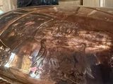 a large metal bowl sitting on top of a wooden table