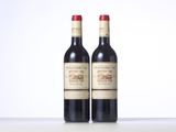 two bottles of red wine sitting next to each other on a table