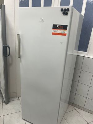 un réfrigérateur blanc dans une pièce aux murs bleus et blancs