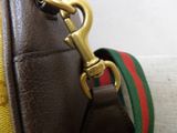 a brown leather bag with a green and red stripe strap