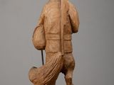wooden statue of a man holding a baseball bat on a table